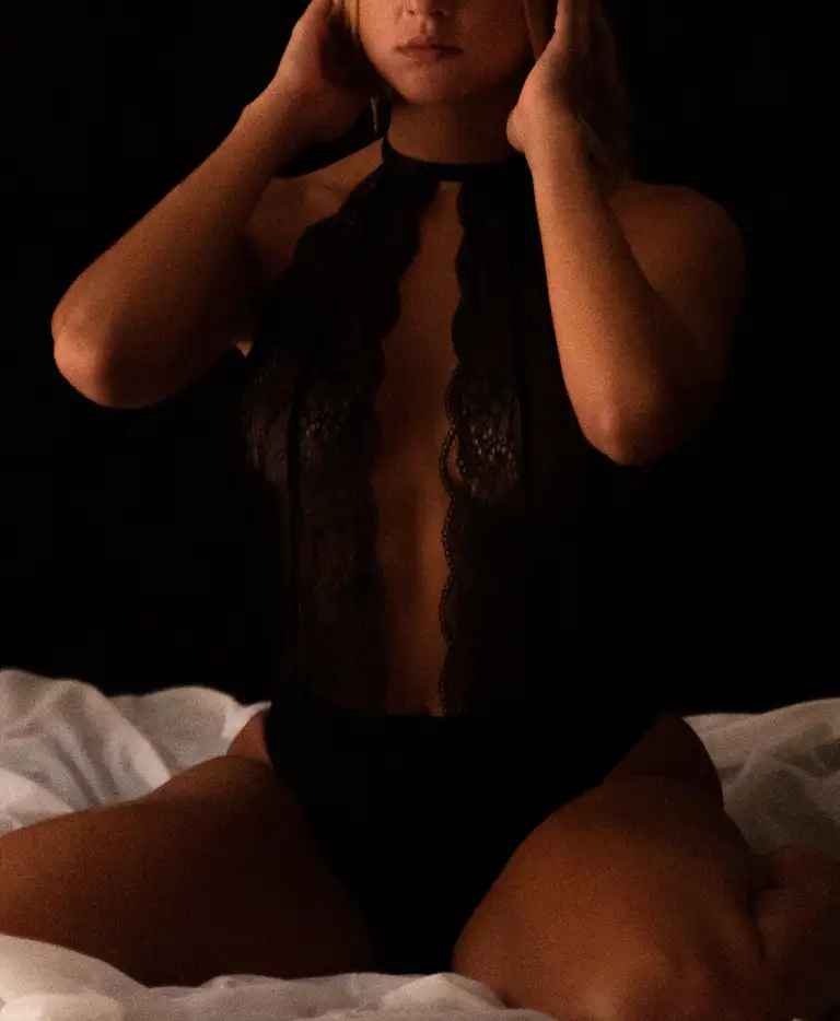 Moody black lace bodysuit lingerie photograph captured in intimate bedroom lighting in Australia, designed for professional portfolio and commercial lingerie presentation.