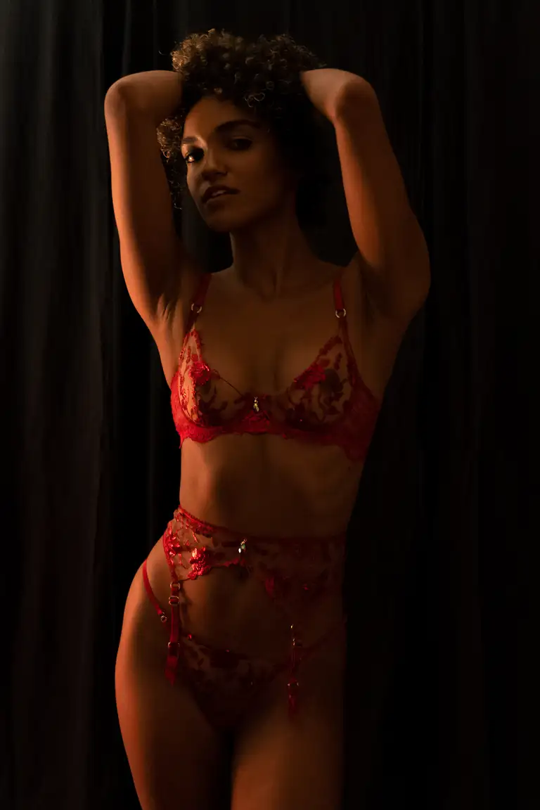 Fashion portrait of a model wearing a red lace Honey Birdette lingerie set, captured in moody light by a Gold Coast photographer for professional modelling portfolio use and lingerie brand content.