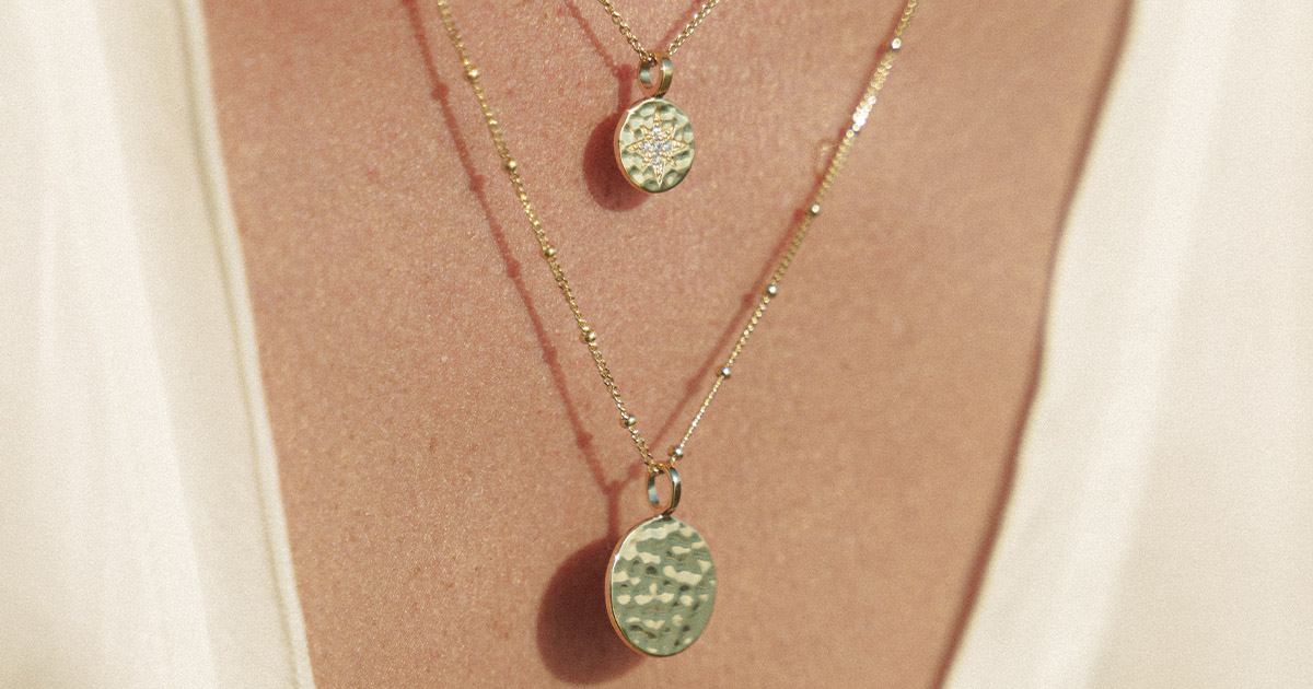 Close-up of layered gold necklaces on skin, photographed in natural light to highlight fine texture and craftsmanship - high-end eCommerce product photography by Bora Veli.