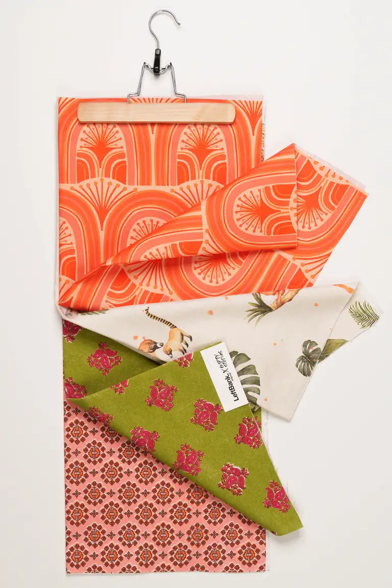 High-end eCommerce image of patterned home décor fabrics in bold orange, green, and pink tones, captured in South East Queensland for textile catalogue display.