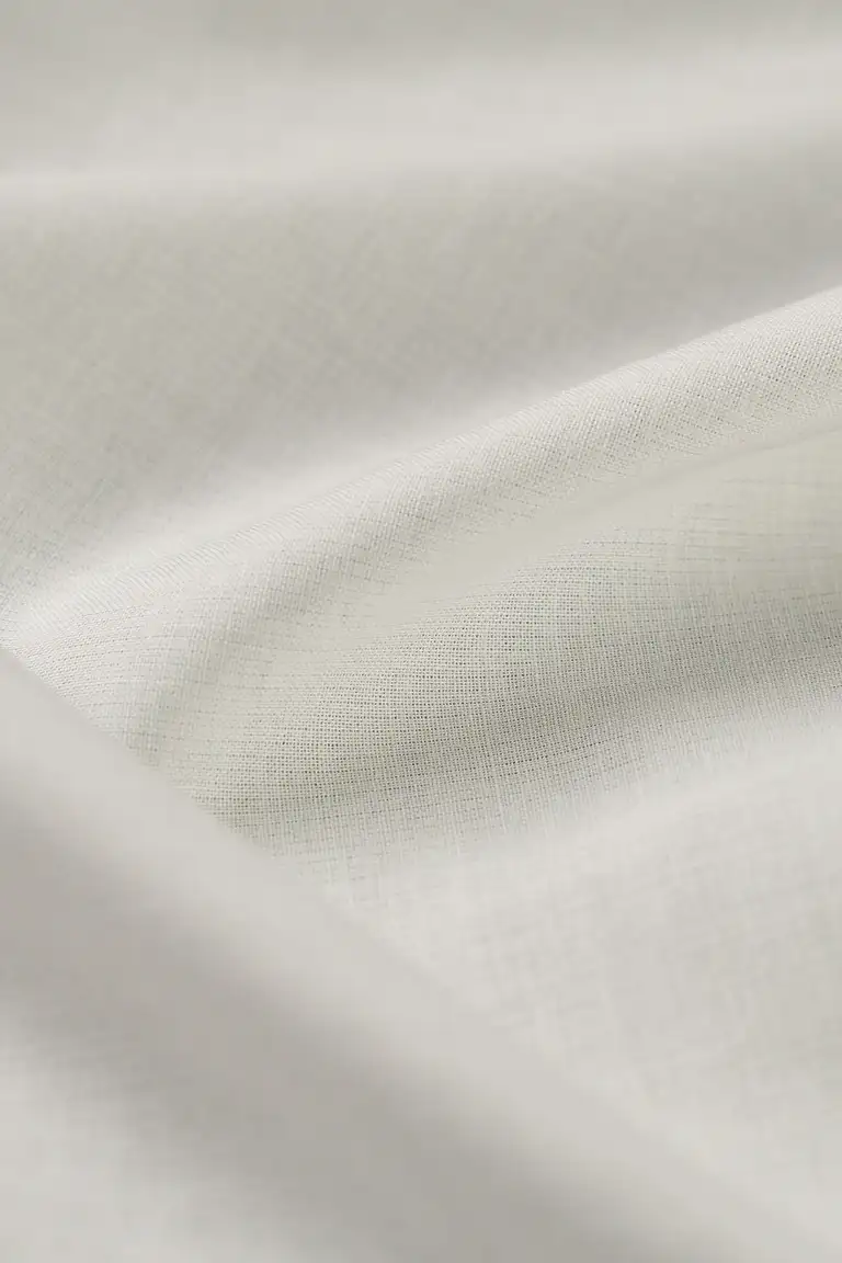 Close-up of soft white voile fabric photographed by a Gold Coast product photographer, showing the fine weave and lightweight texture in elegant eCommerce style.