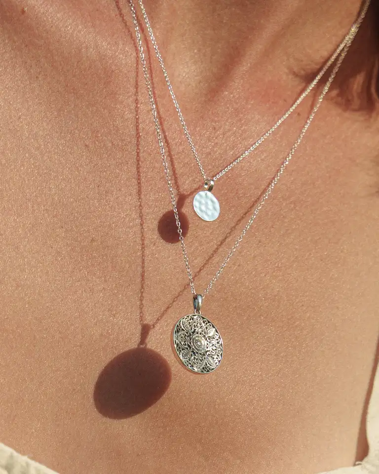 Close-up detail of layered silver necklaces in natural light, photographed by a South East Queensland eCommerce photographer in an elegant, minimalist style.