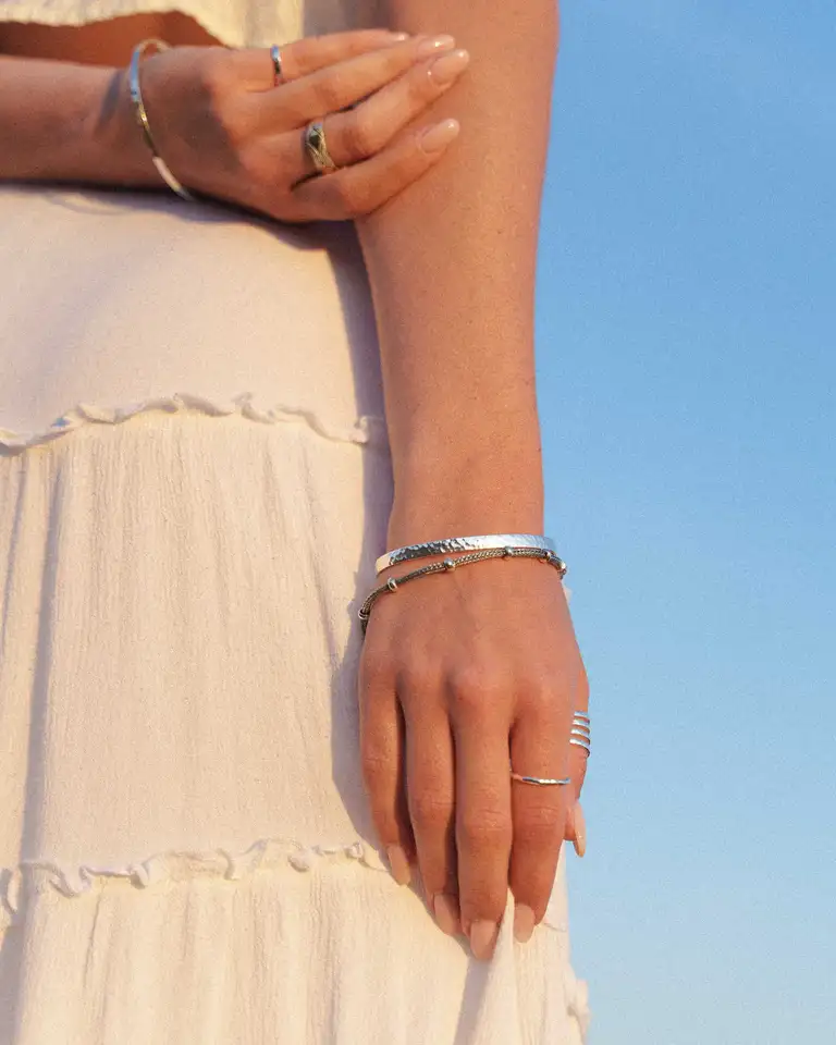 Lifestyle jewellery product photo showcasing bracelets and rings with soft, warm tones, photographed in England with a high-end eCommerce aesthetic.