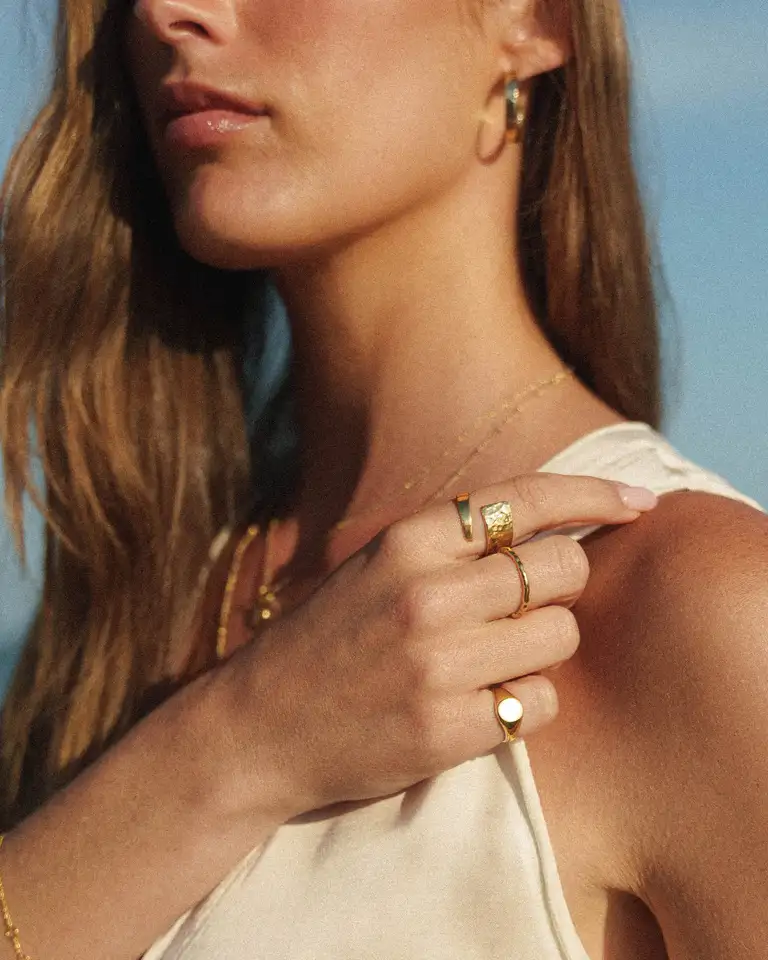 Lifestyle jewellery portrait highlighting gold statement rings and earrings, photographed in Australia with a high-end eCommerce style and bohemian vibe.